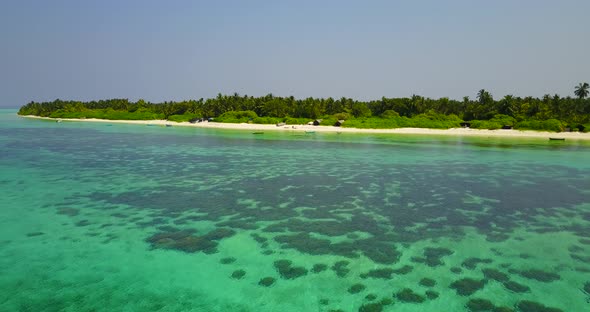 Daytime drone travel shot of a white paradise beach and blue ocean background