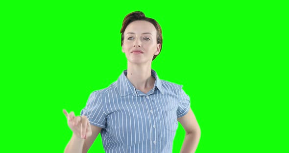 Caucasian woman raising hand on green background