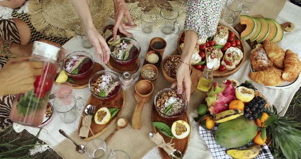 Girls ' Hands Take Wooden Plates with Vegetarian Food During a Picnic