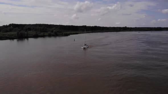 Aerial View Of Oude Maas With Sail Boat Going Past Near Barendrecht, Netherlands. Tracking Shot