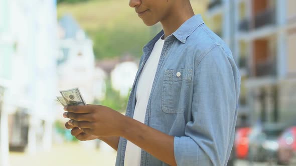 Teen Boy Counting Money Considering Purchase