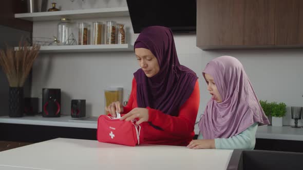 Worried Lovely Muslim Mom Looking for Medicine in First Aid Kit to Coughing Sick Little Daughter