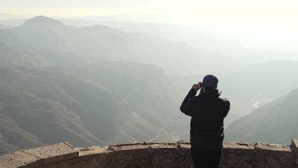 The guy on the observation deck looks at a beautiful view of the mountains