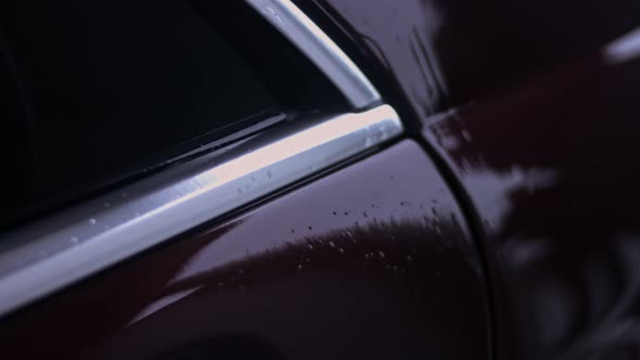 Unrecognizable Person Uses a High Pressure Jet Water to Wash Off the Foam and Dust From the Car on a