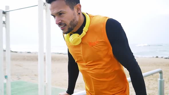 Man training at the beach outdoor gym