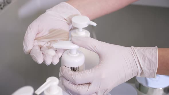 Girl Doctor in Rubber Gloves Squeezes Out a Bottle