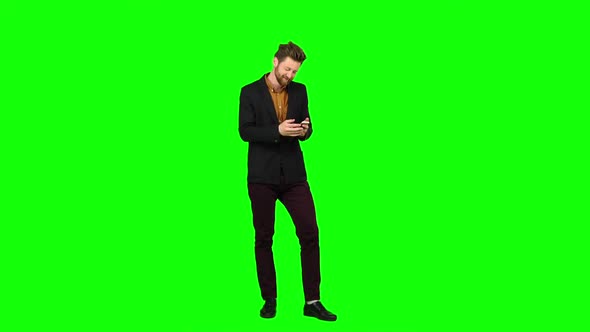 Man Looks at the Phone in the Photo, and Has Fun. Green Screen