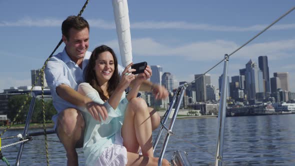 Young couple on sailboat together using cell phone. Shot on RED EPIC for high quality 4K, UHD, Ultra