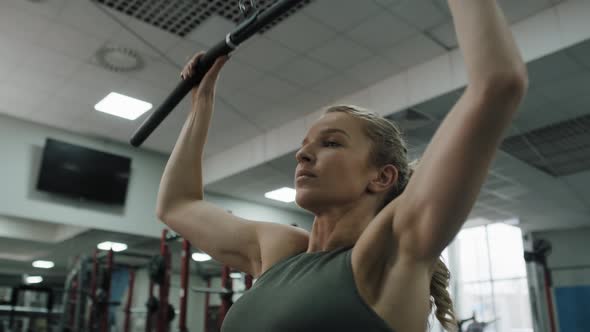 Young woman  exercising with weights  on a gym. Shot with RED helium camera in 8K.