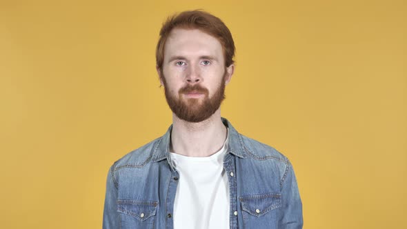 Redhead Man Looking at Camera, Yellow Background