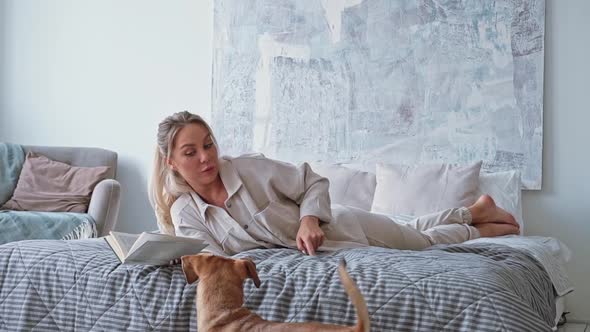 Young Beautiful Woman Reading Book with Small Brown Dachshund Dog