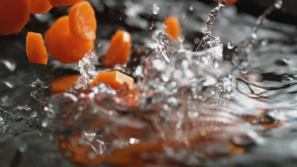 Throwing cut carrot into boiling water. Slow Motion.