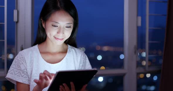 Young woman use of tablet computer at night