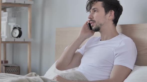 Man Talking on Phone While Lying on Side in Bed