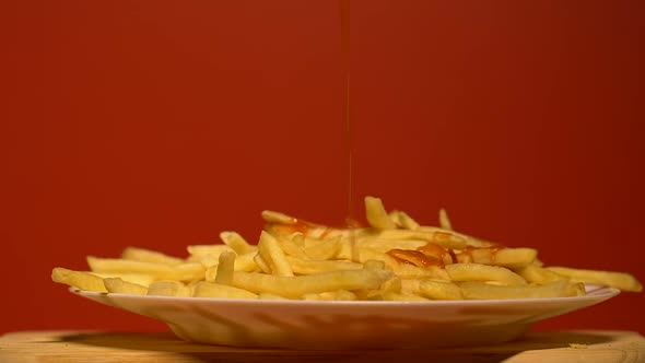 Ketchup Dropping on Plate Full of French Fries, Unhealthy Junk Food, Overeating