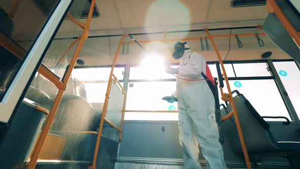 Coronavirus Pandemic Concept, Disinfection Process. Specialist Is Disinfecting Bus Interior with