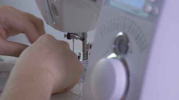 Hands sewing at an electronic sewing machine