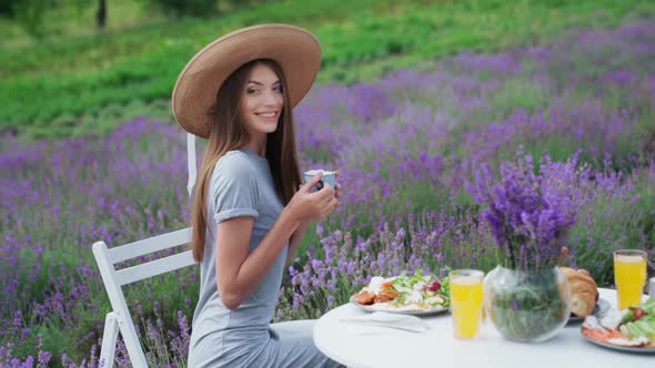 Smiling Girl Drinking Coffee in Lavender Field