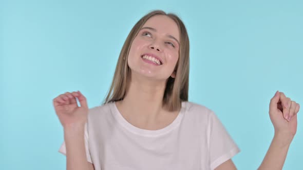 Beautiful Young Woman Dancing To Music, Blue Background