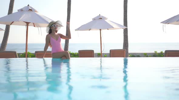 Young asian woman enjoy around outdoor swimming pool for leisure