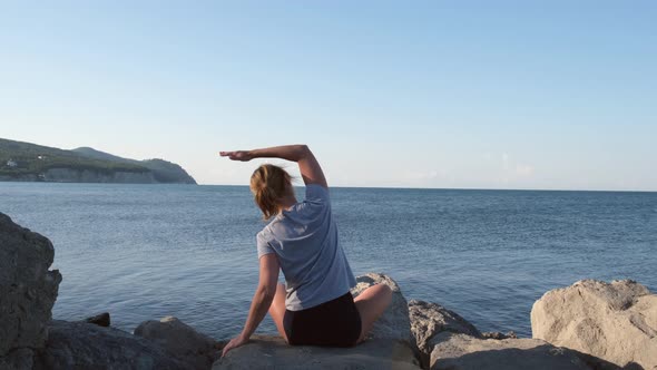 Caucasian Woman Doing Stretching Exercises at Seashore