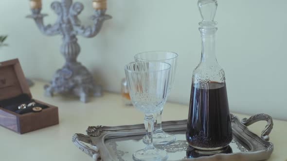 A carafe of red wine on the background of wedding rings. Wedding preparation