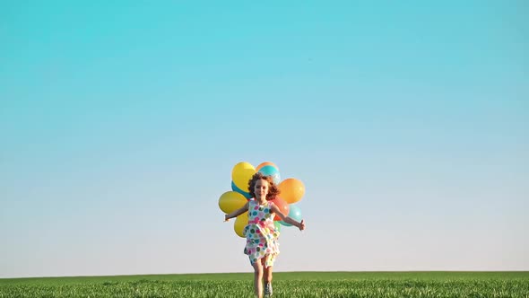 Happy Child Playing with Bright Multicolor Balloons