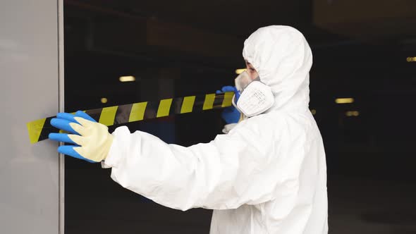 Confident Female Disinfectant Closing Quarantine Zone Using Warning Tape