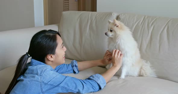 Woman cuddle her Pomeranian dog at home