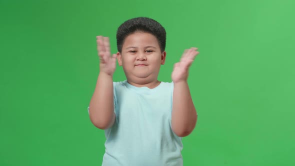 Asian Little Boy Clapping His Hands In The Green Screen Studio