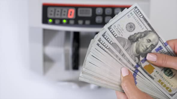 Closeup of business woman hand hands counting US dollar cash.