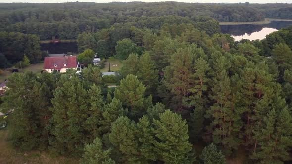 Spectacular aerial flight panorama curve flight drone shot of a house on a lakein nature reserve Mü