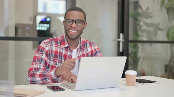 African Man Showing Thumbs Up Sign While Using Laptop