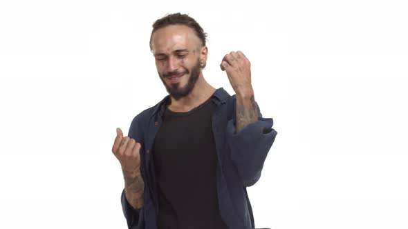Cheerful Handsome Hipster Guy with Beard Tattoos on Face and Body Saying Hooray and Celebrating