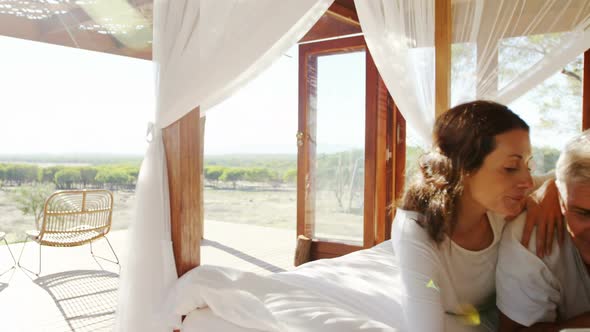 Happy couple using digital tablet on bed 4k