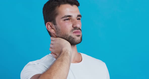 Young Man Suffering From Pain in Neck, Warming Up His Head
