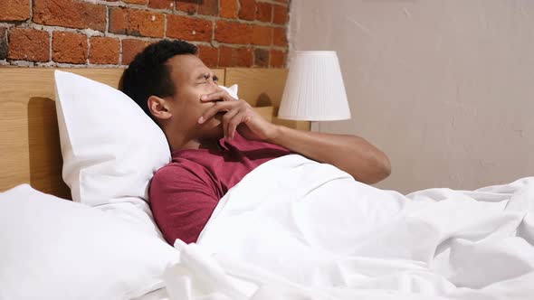 Sick African Man Lying in Bed at Night, Feeling Uncomfortable