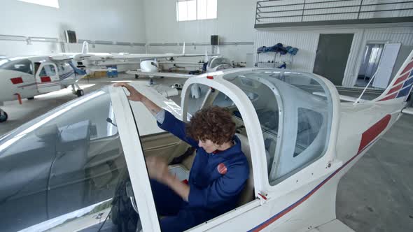 Woman Pilot Sitting in Cabin of Jet Airplane