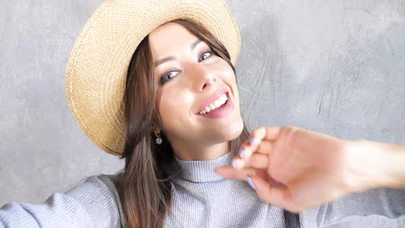 Beautiful young trendy woman in hat. Girl smiling and looking on camera