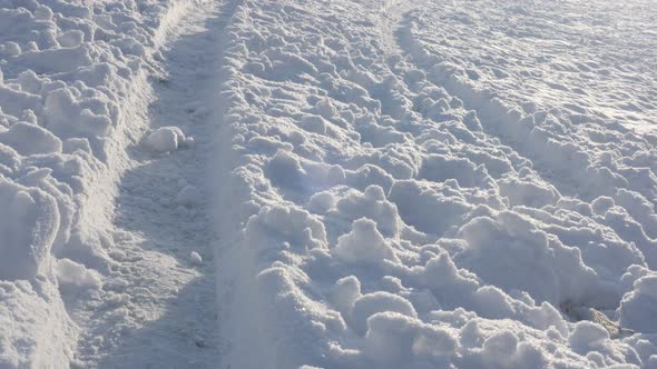 Traces in snow of vehicle tyre slow tilt 4K 2160p 30fps UltraHD footage - Tilting over snow dunes on