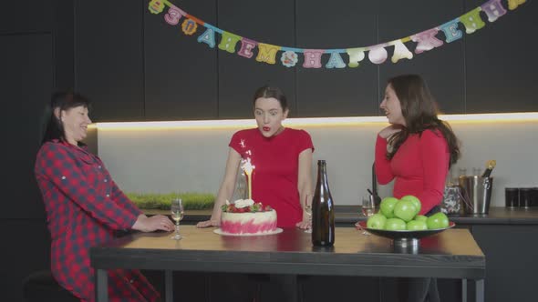 Happy Woman Blowing Candle on Birthday Cake