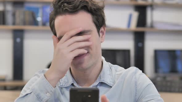 Portrait of Creative Man Reacting to Loss While Using Smartphone