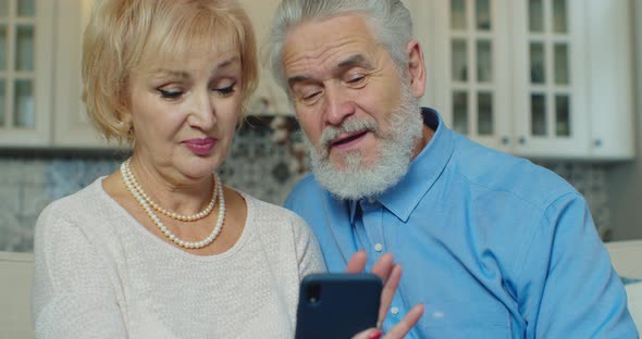Positive Grandmother and Grandfather Call Video Online on Smartphone