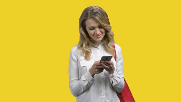 Young Woman Answering a Message Against Yellow Background