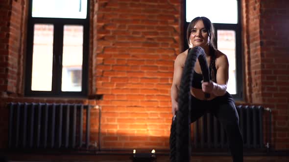 Front View of Young Athletic Woman with Strong Beautiful Body Wearing Black Activewear Exercising