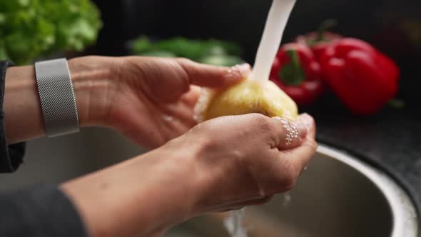 Female Holding Quince Fruit in Hands Washing and Cleaning It Under Water