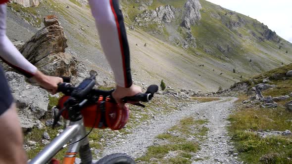 A man mountain biking on a European mountainside biking trail.