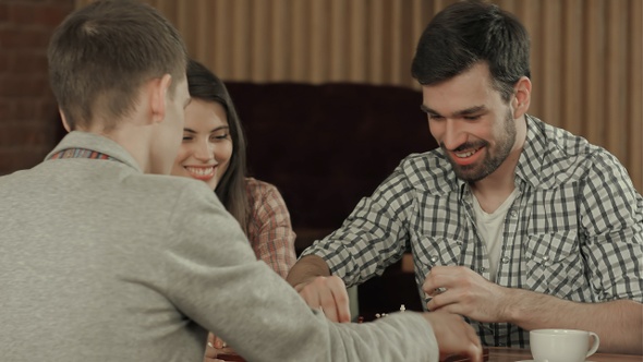 Friends have a rest in a cafe and play a chess