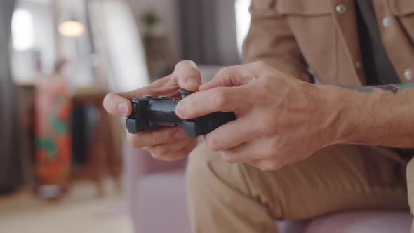 Hands of Man Using Controller and Playing Console Game