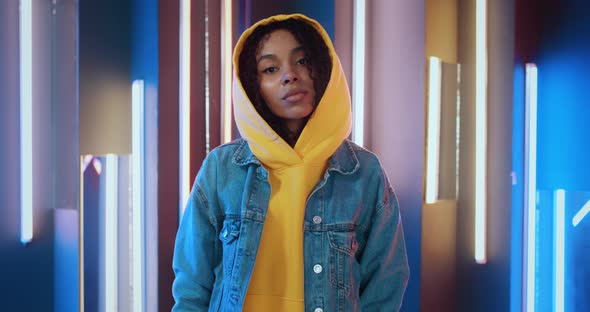 Portrait of Stylish Urban African American Black Woman in Yellow Hoodie and Jeans Jacket Standing in